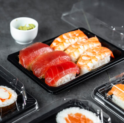 プラスチック食品容器（寿司トレイタイプ）にぎっしり詰まった新鮮な寿司。透明なフタで中身が見やすく、持ち運びにも便利な設計です。