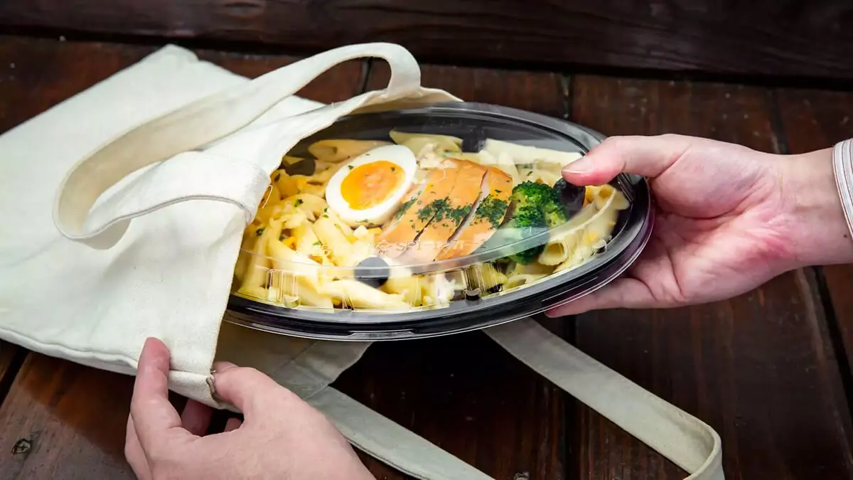 テイクアウトのパスタをバッグに入れる画像
