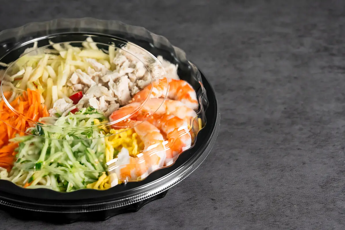 サステナビリティに配慮した、リサイクル可能な高品質な耐熱容器。料理の鮮度をクリアに伝える透明な蓋と耐久性のある黒いベースの組み合わせ。