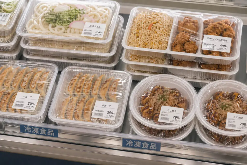 トップシール包装を採用した、スーパーマーケットの売場に並ぶ冷凍食品や惣菜の陳列例。